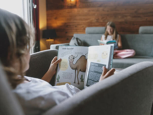 Ein Junge und ein Mädchen lesen Bücher auf dem Sofa in der Suite