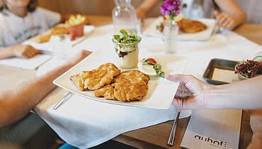 Familie genießt ein gemütliches Mittagessen im Restaurant des Hotel Auhof Kaprun