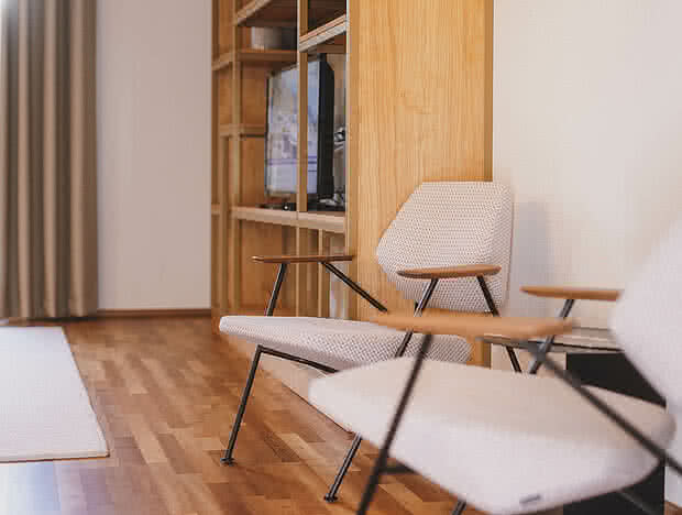 Zwei Designer Stühle vor einem Regal mit Fernseher und Dekorationen in einem gemütlichen Raum